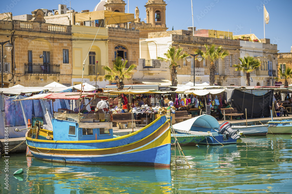 Marsaxlokk, Malta - Colorful, traditional Luzzu fishing boats at Marsaxlokk market on a sunny summer day