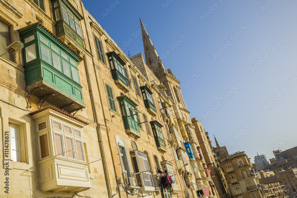 Valletta, Malta - The old houses and traditional maltese colorful balconies of Valletta at sunset