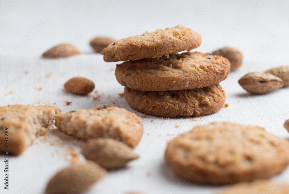 Cookies pile with chocolate chip and almond on light textile background. Delicious morning snacks for breakfast, brunch and lunch. Appetizing, healthy and fast food Cookies pile with chocolate chip and almond on light textile background. Delicious morning snacks for breakfast, brunch and lunch. Appetizing, healthy and fast food