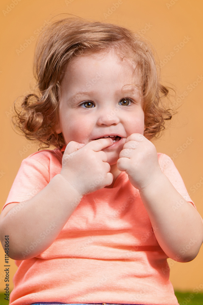 One cute baby girl on orange background One cute baby girl on orange background