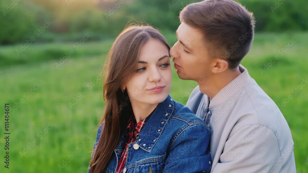 Young couple embracing. The guy embraces and kisses the girl Young couple embracing. The guy embraces and kisses the girl