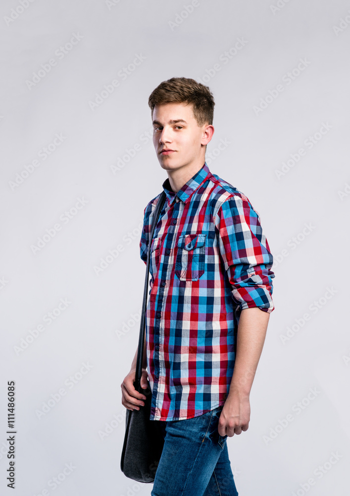Fototapeta premium Boy in jeans and shirt, young man, studio shot