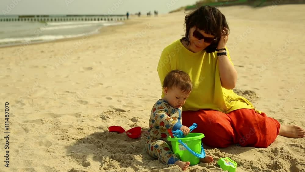 Mother with baby plays in the sand at the beach
Mother with baby plays in the sand at the beach