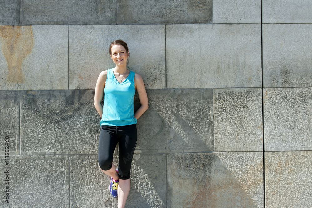 Woman resting after run by the wall urban. Woman resting after run by the wall urban.
