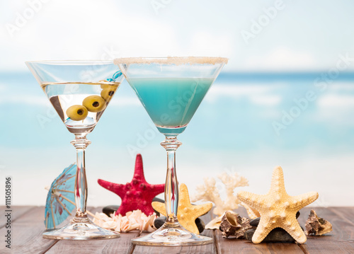 Cocktails, starfish and sinks on sea background.