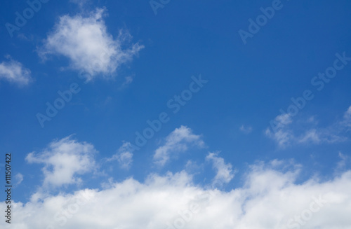 Cloudscape over horizon, white clouds in the blue sky.