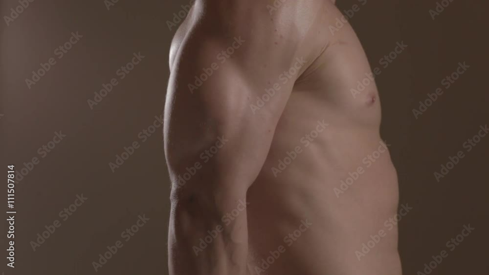 Brutal guy showing his muscles. Triceps. Ungraded Brutal guy showing his muscles. Triceps. Ungraded
