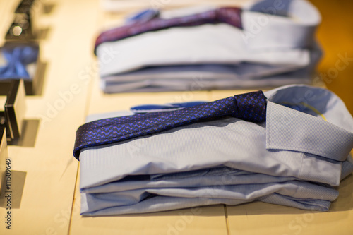 close up of shirts with ties at clothing store