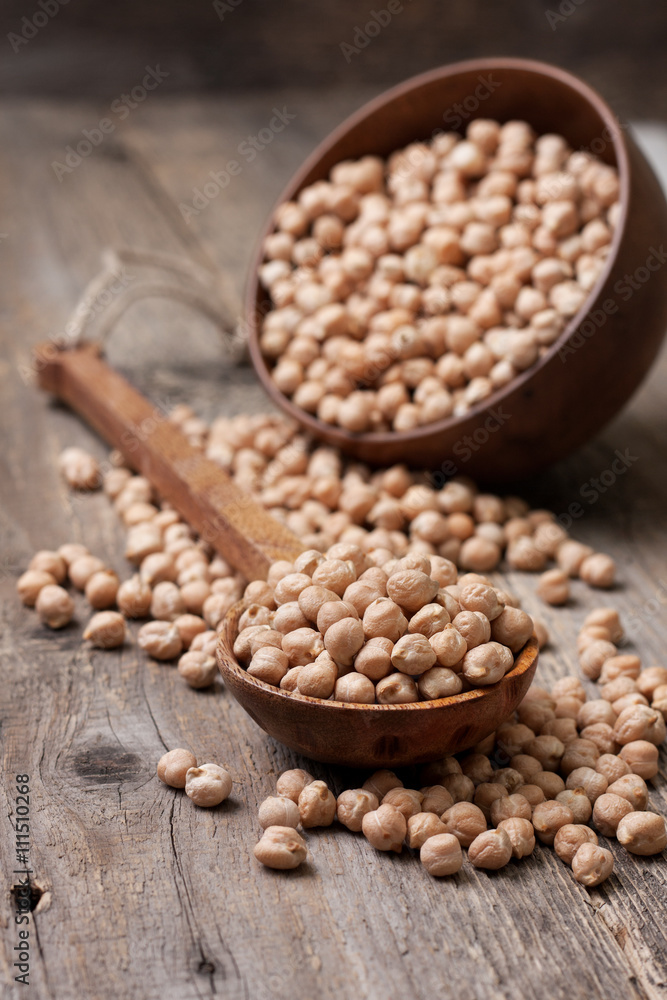 dried chickpeas in a wooden spoon dried chickpeas in a wooden spoon