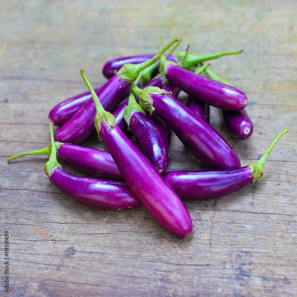 Purple eggplants on wooden background. Purple eggplants on wooden background.