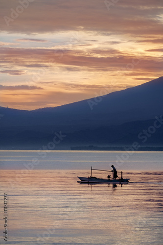 Oriental fisherman in the sea at sunrise