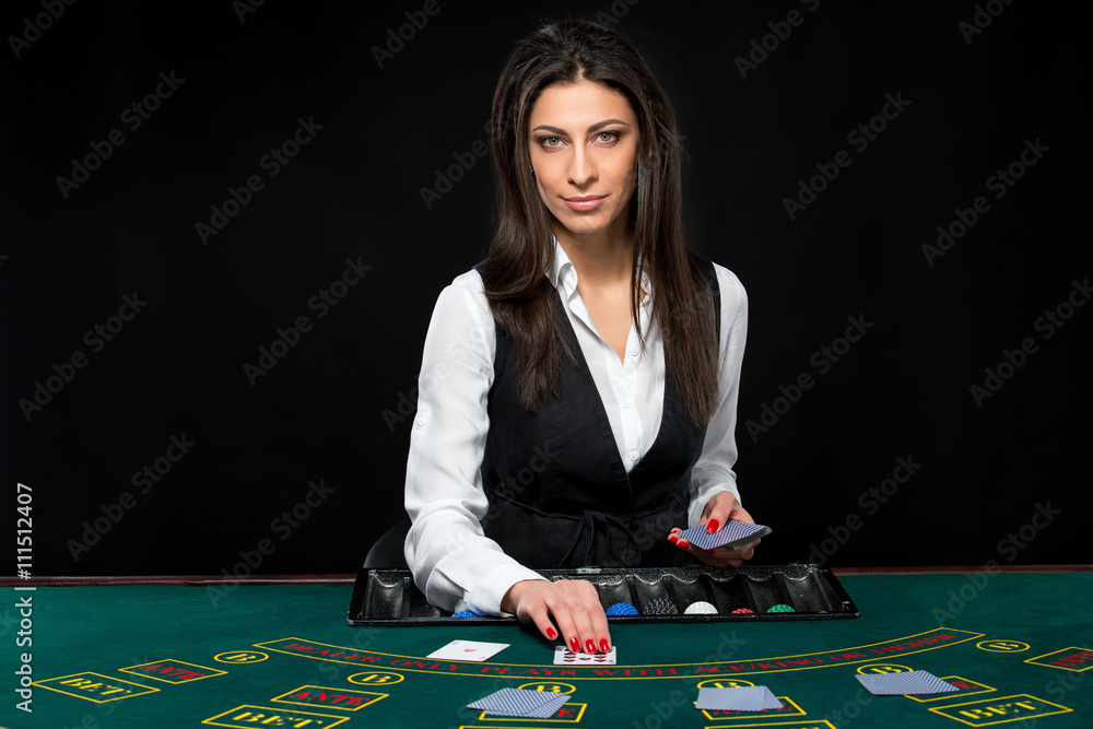 The beautiful girl, dealer, behind a table for poker The beautiful girl, dealer, behind a table for poker
