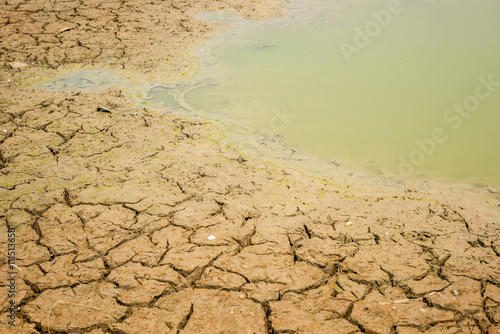 cracked soil in the bottom of a river showing drought