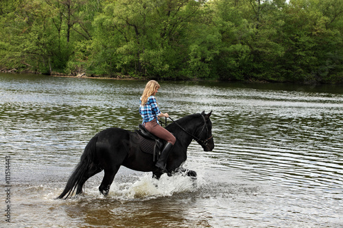 Young lady riding horseback in the river © horsemen
