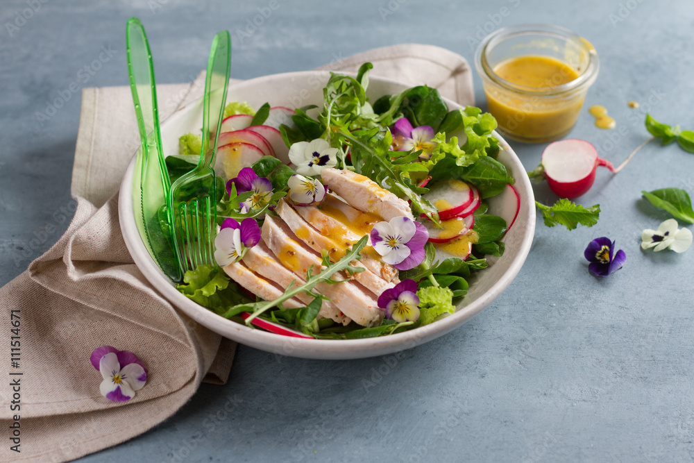 Spring salad with radishes, chicken breast and edible flower