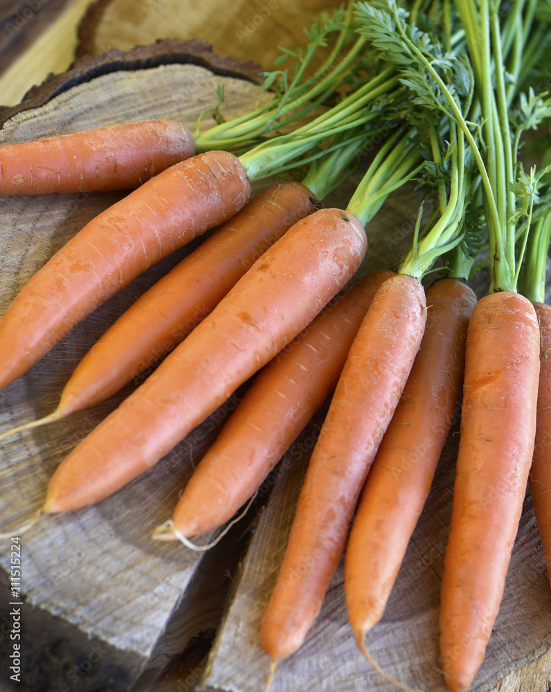 Fresh carrots bunch on rustic wooden background Fresh carrots bunch on rustic wooden background
