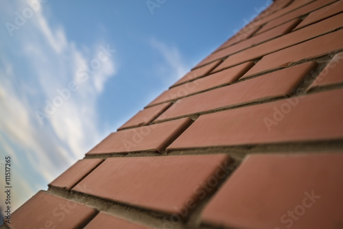 Background of close up urban red brick wall and sky with clouds