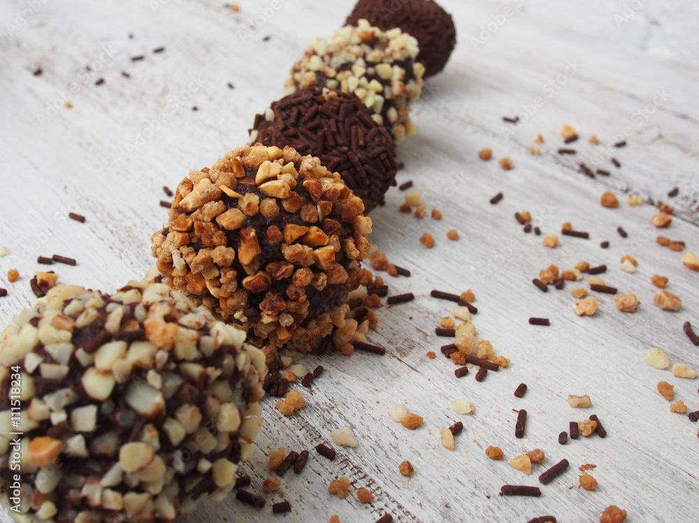 Assorted dark chocolate truffles with cocoa powder,chopped hazelnuts and berries Assorted dark chocolate truffles with cocoa powder,chopped hazelnuts and berries