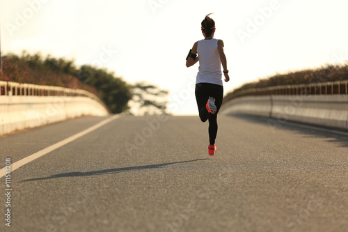 young fitness woman runner running on road