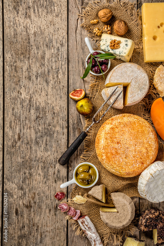 Various kind of cheese and delicacy on wood