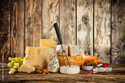 Fotografija Various types of cheese placed on wooden table
