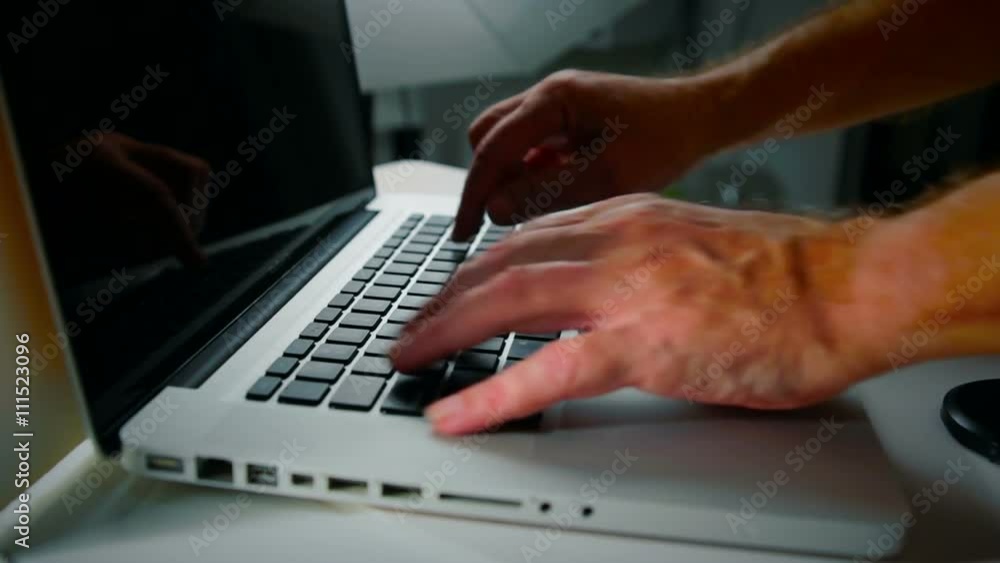 Man Typing on a Laptop - Low Angle with Contrast. Man typing on a laptop shot with a narrow depth of field and contrast. Man Typing on a Laptop - Low Angle with Contrast. Man typing on a laptop shot with a narrow depth of field and contrast.