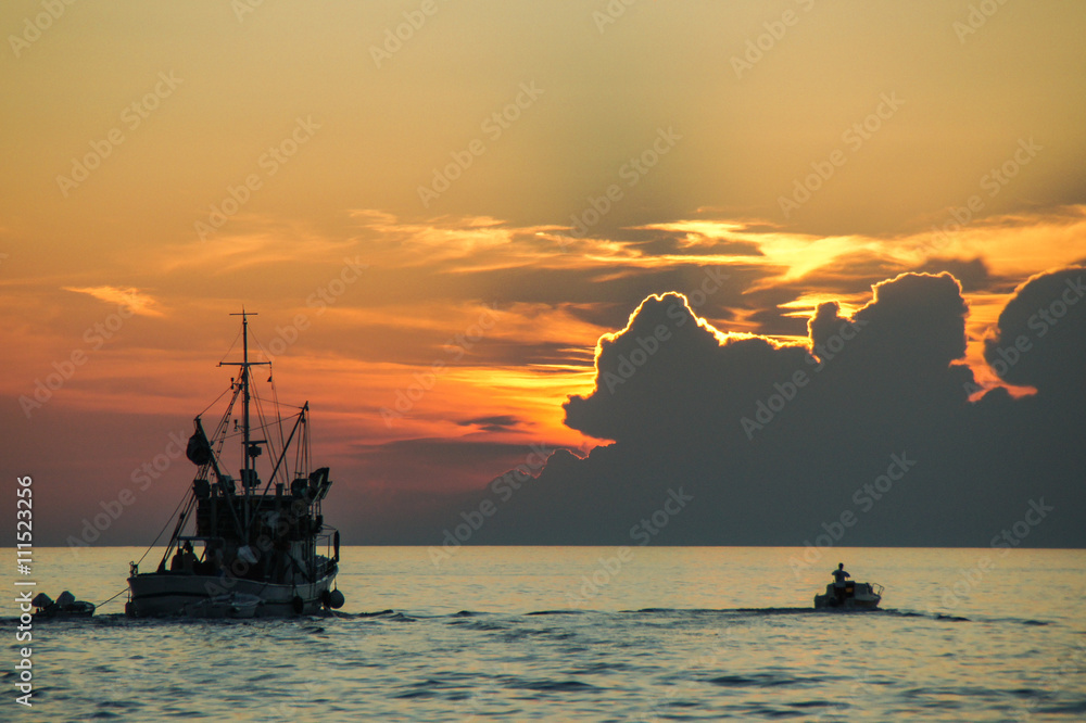 Fischerboot fährt in den Sonnenuntergang