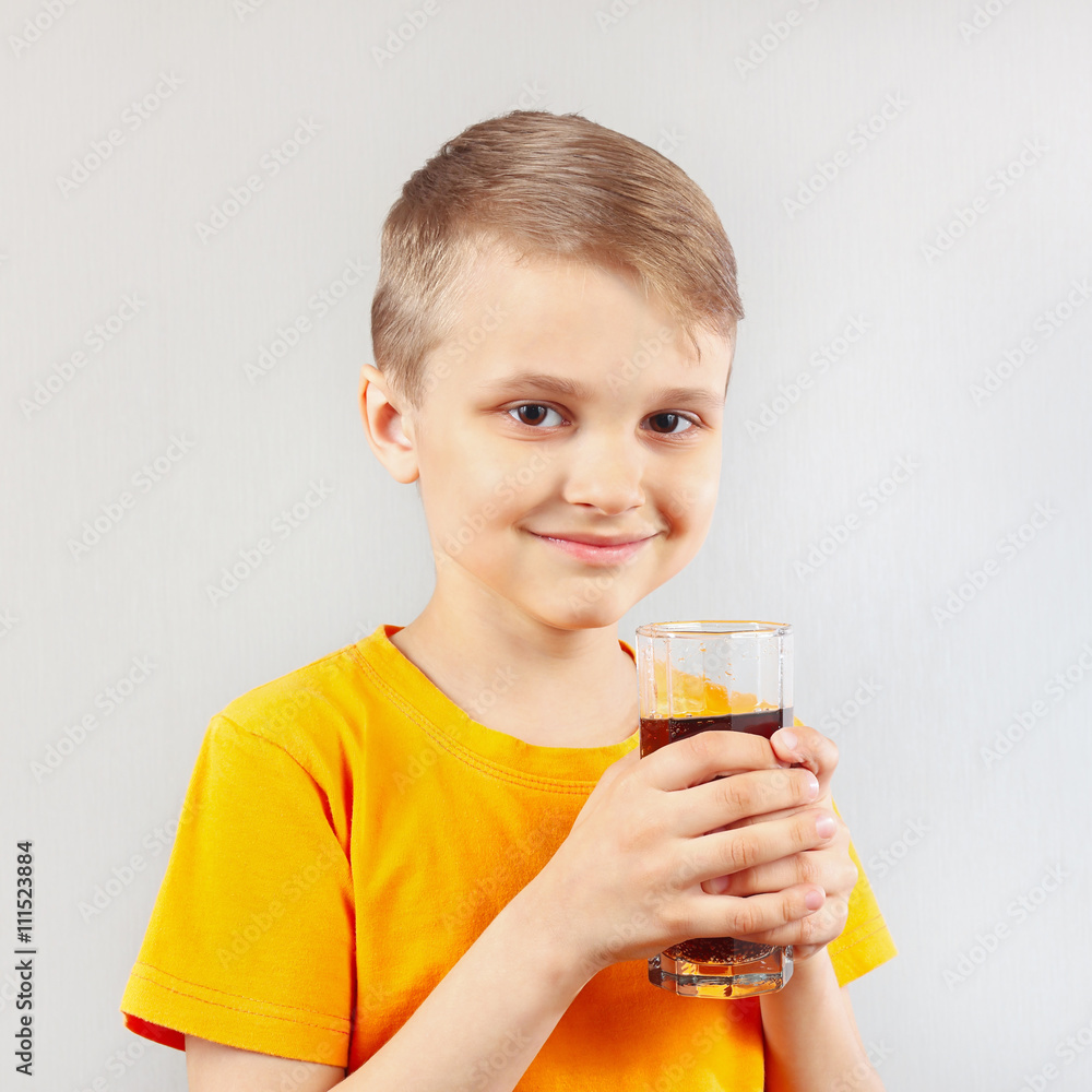Little blonde boy with a glass of fresh cola Little blonde boy with a glass of fresh cola