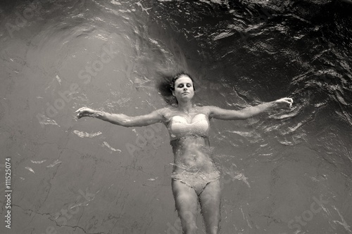 Junge Frau schwimmt in einem Pool, aus der Vogelperspektive fotografiert