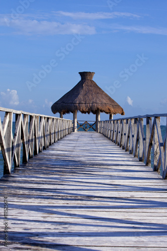 Fototapeta Naklejka Na Ścianę i Meble -  Tropical pier that stretched out in to the crystal blue sea.
