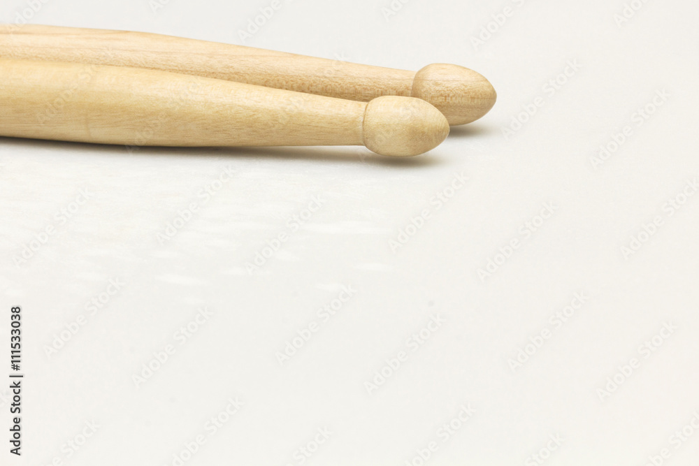 A pair of new wooden drumsticks on a drum patch. A pair of new wooden drumsticks on a drum patch.