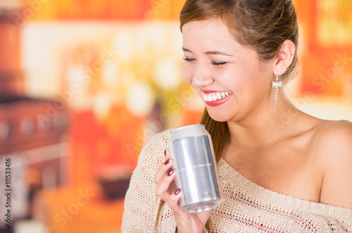 pretty brunette and an blank soda can, smiling