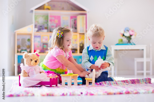 Obraz na płótnie Kids playing with stuffed animals and doll house