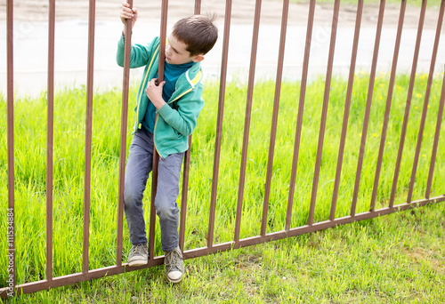 illegally entering. child crawls through the bars of the iron fence