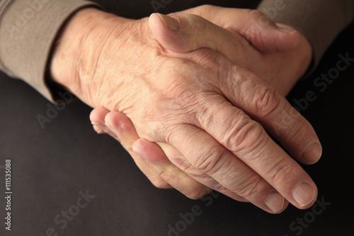 Older man holding his numb hand 