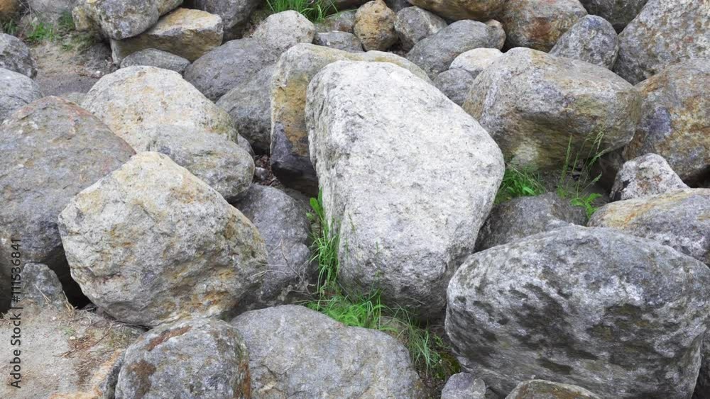 Group of big boulder stones lying in field, natural geologic background, panning view Group of big boulder stones lying in field, natural geologic background, panning view