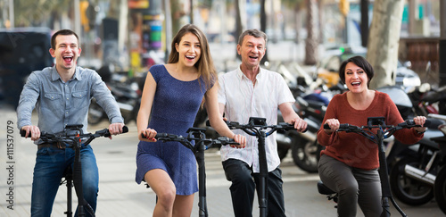 Smiling family of four with electrkc bikes photo