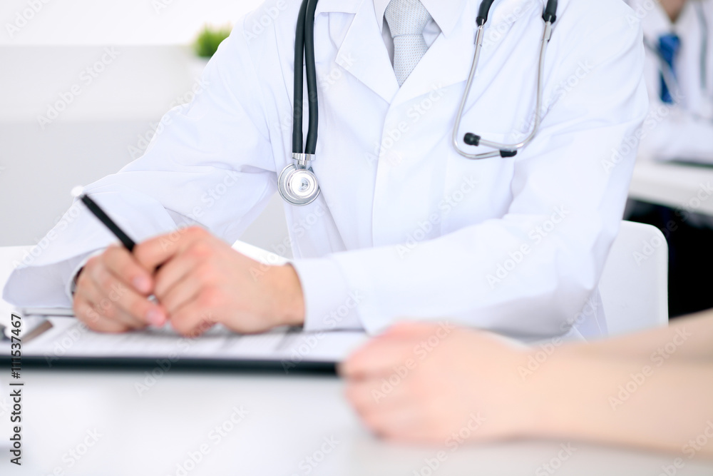 Doctor and patient are discussing something, just hands at the table Doctor and patient are discussing something, just hands at the table