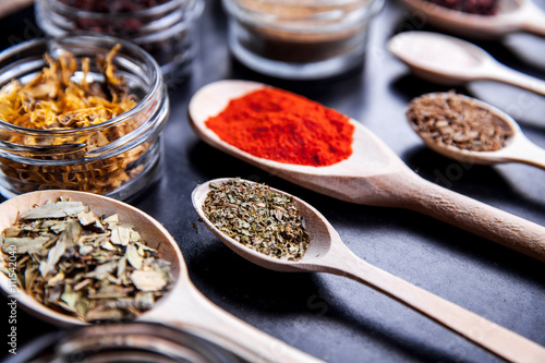 Spices on black background in special jars. Food