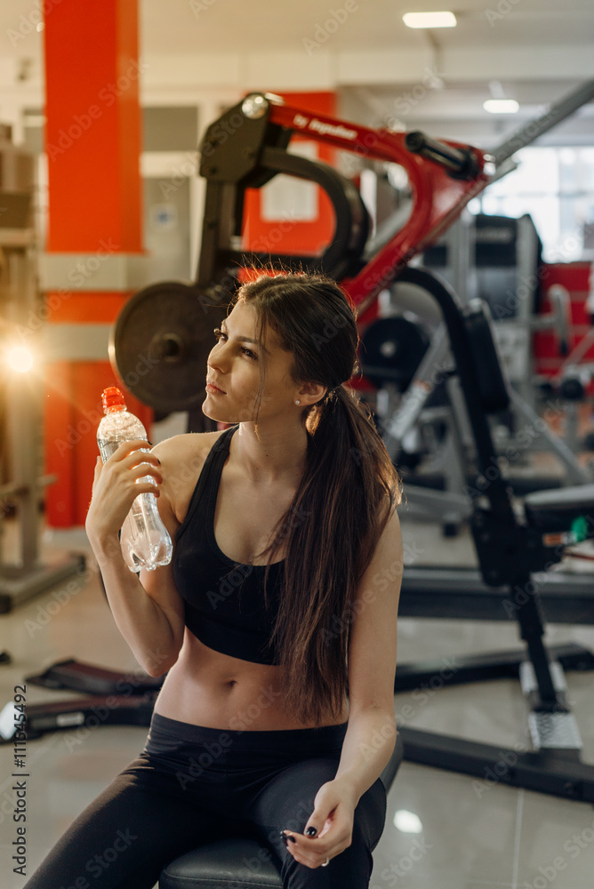 Fototapeta premium Beautiful girl with water at the gym