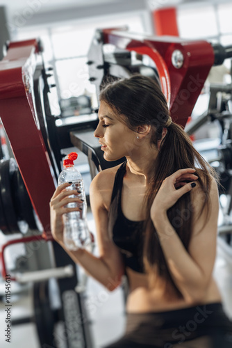 Beautiful girl with water at the gym