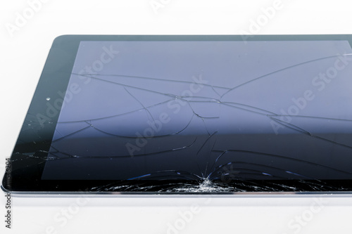 Broken iPad with a shattered glass screen on white background