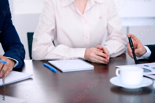 Group of business people and lawyers discussing contract papers sitting at the table, close up