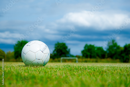 Old football on green grass in Stadium on blue sky  Old soccer ball  soccer field