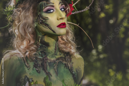 Fotografia Model woman in the form of a nymph among the trees unusual fancy