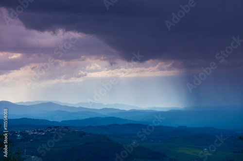 Cloudy rainy sky over mountain valley. Tyscany, Italy