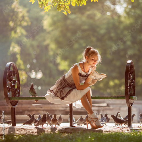 Εκτύπωση καμβά Beautiful model reading a book on a park bench