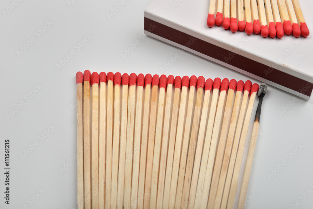 Naklejka premium Many red head matches and one burned put straight in line near a