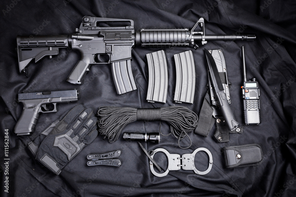 Rifle, gun, knife with sheath, compass and notebook with pen on on black cloth Rifle, gun, knife with sheath, compass and notebook with pen on on black cloth