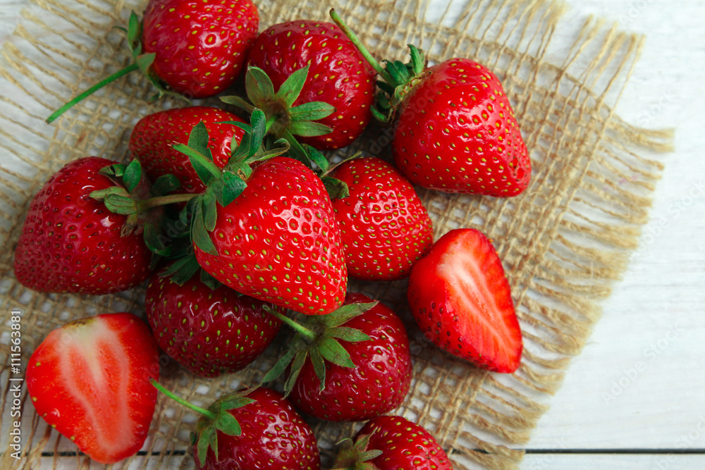 appetizing strawberries on burlap on white wooden background appetizing strawberries on burlap on white wooden background